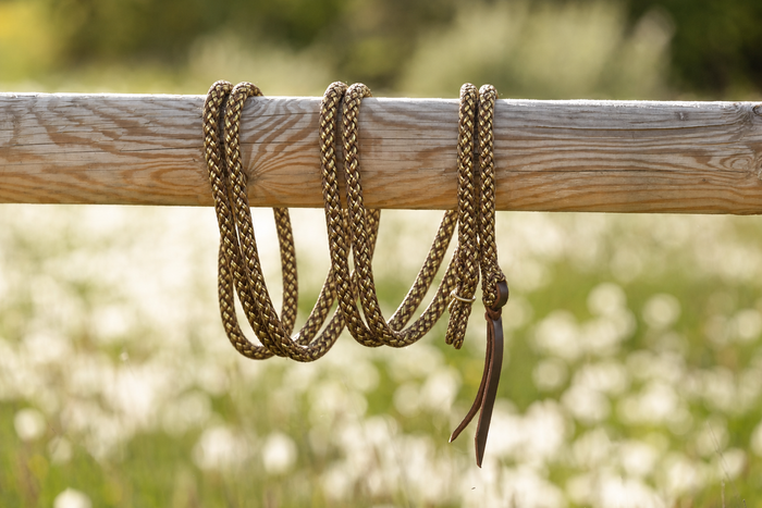 Duogold — Gaucho rope with gold hardware on a wooden beam